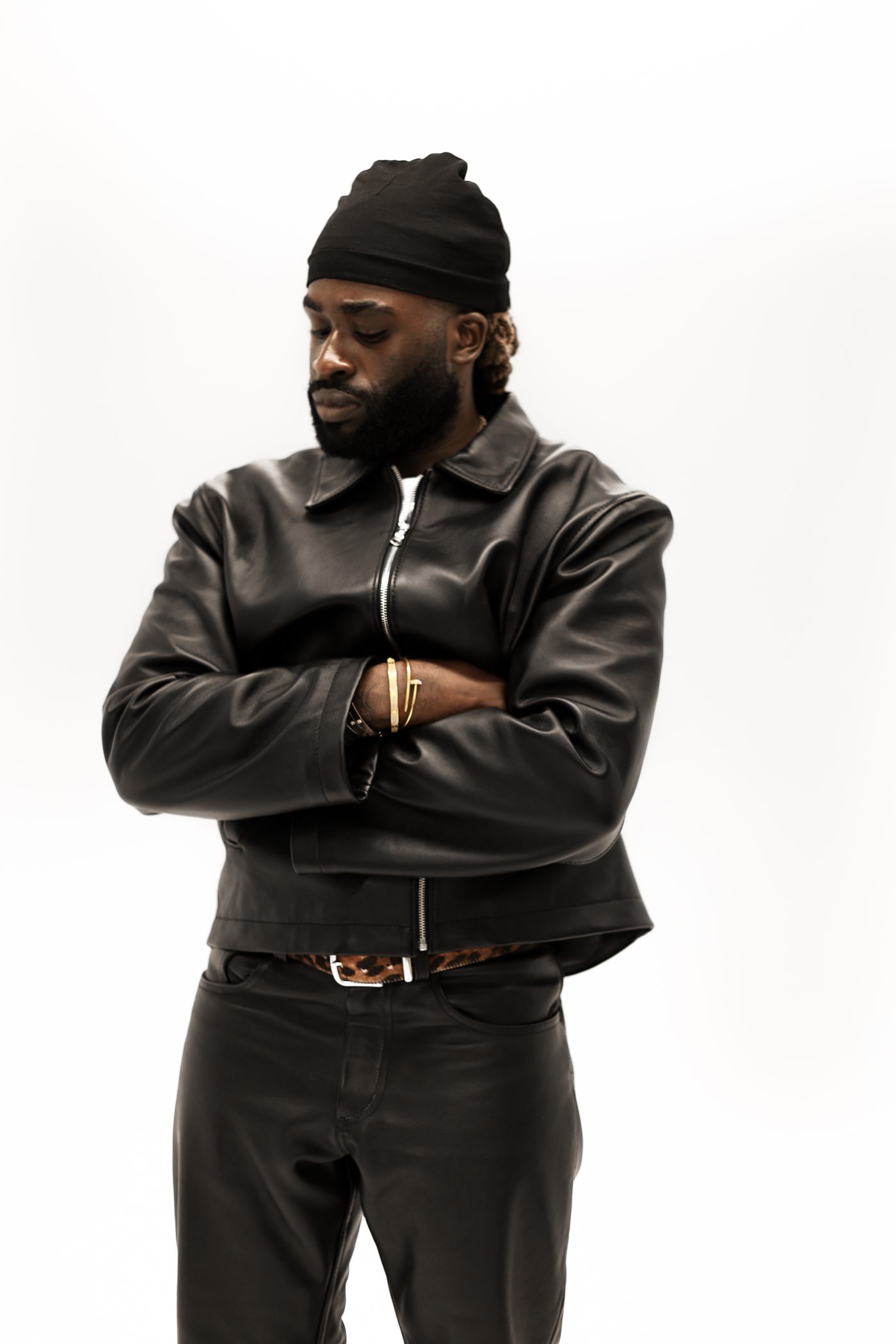 Model wearing Noir jacket, arms crossed, looking down